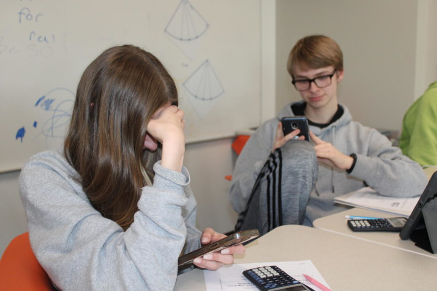 Freshmen Sophia Opryszko and Caleb Zellener use their phones during free time in math class.  