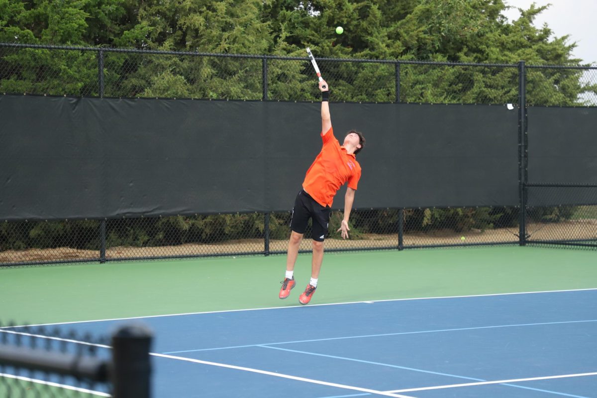Sergio Dávila, 12, reaches his arm all the way up as he makes his serve. Dávila jumped into the air, crushing the ball across the court, for the ace.  