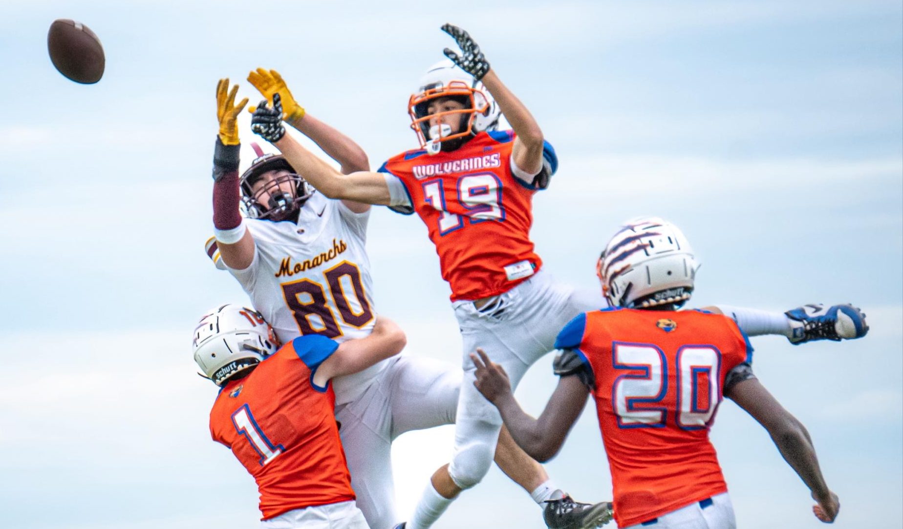 Joey English, 10, leaps into the air to make the catch as his teammate takes down the defender.
