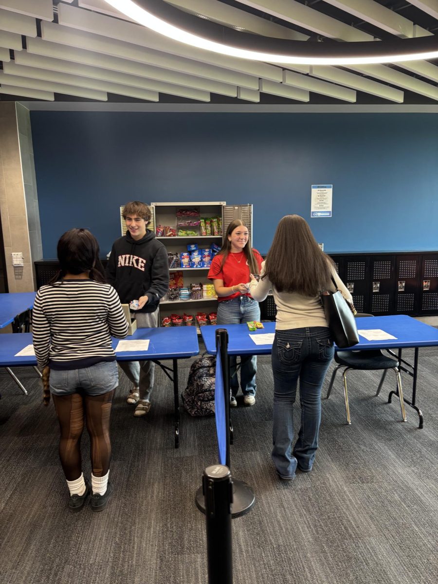 Junior Deca officers Jenna Smith, and Josh Frakes serve customers at the snack shack. The shack is located on the first floor across from the counseling center.  
