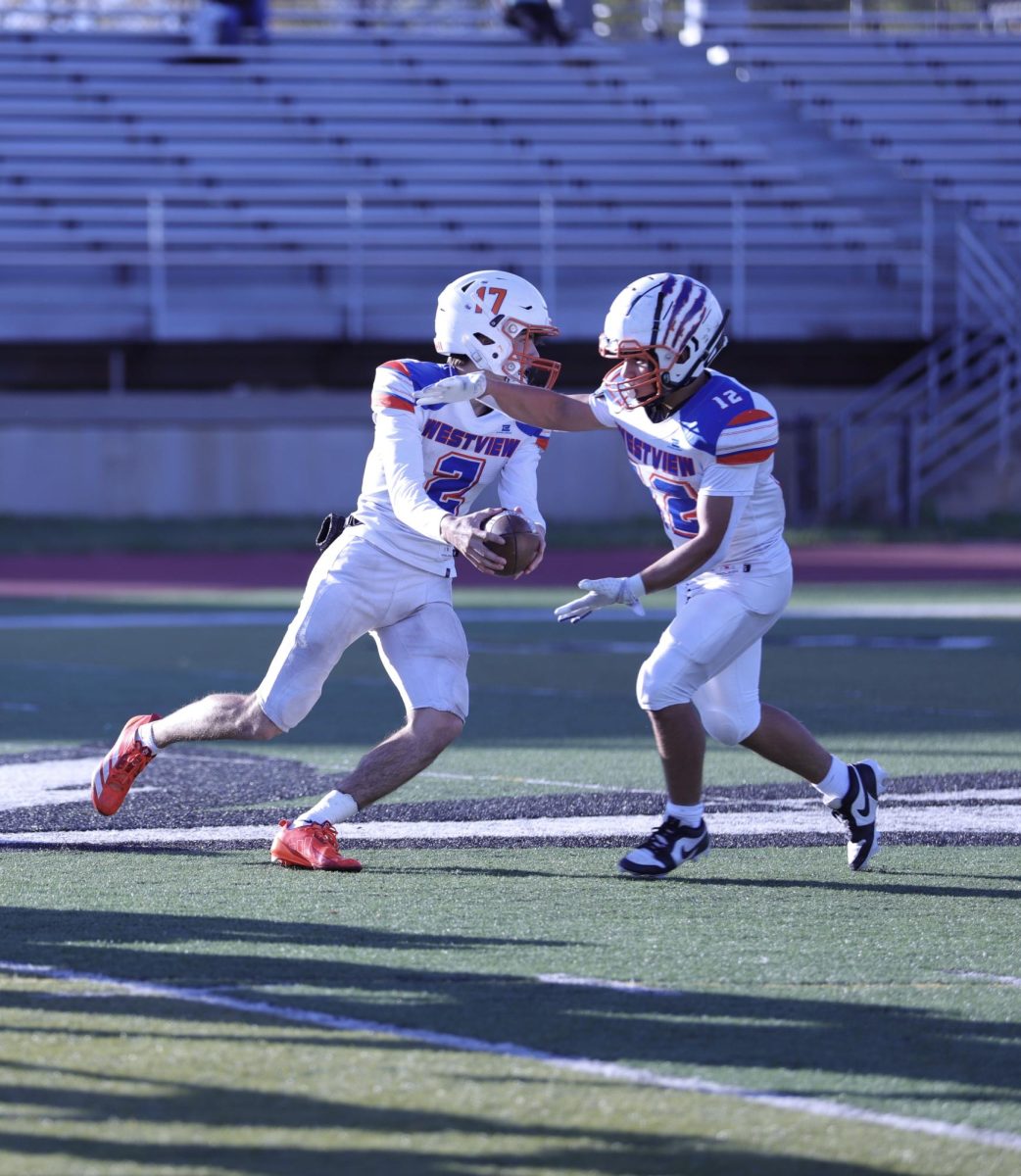 Landen Bader, 10, hands the ball off to Mauricio Granados Bermudez, 10, for the run play. Bader and Granados Bermudez both scored a rushing touchdown during this game.